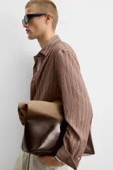 Bolso tipo shopper de piel con acabado en serraje lacado, color marrón degradado. Tiene un compartimento principal con cierre de imán y un bolsillo interior con cierre de cremallera.