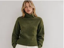 Sweater de cuello alto en color verde musgo, con diseño de tejido de punto suave, corte relajado y terminaciones acanaladas en cuello, puños y cintura.