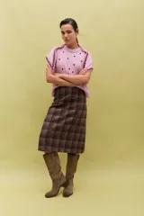 Falda midi de corte recto con estampado de cuadros en tonos tierra y líneas en contraste. Presenta un diseño estructurado y elegante, confeccionada en tejido de lana con forro interior.