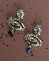 Aros colgantes de bronce dorado con diseño orgánico y perla de río natural en el extremo inferior.