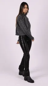 Pantalón negro de tiro alto, corte ajustado y confeccionado en gabardina elastizada con acabado metalizado.