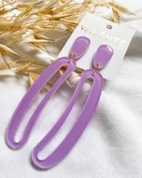 Par de aros colgantes de acrílico color lila, con forma geométrica alargada.