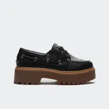 Zapatos tipo náutico Timberland con plataforma dentada color marrón. El cuerpo es de cuero negro con detalles de ojalillos metálicos y un panel superior con estampado animal print texturizado.