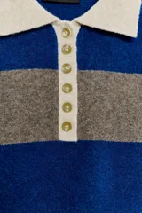 Jersey de punto a rayas horizontales azules y grises, con cuello tipo polo en color beige y cierre frontal con botones.