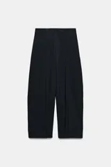 Pantalón de tiro medio con diseño wide leg, confeccionado en tejido con viscosa. Presenta un patrón de rayas diplomáticas, bolsillos laterales ocultos y detalle de pinzas pronunciadas en el delantero. Cierre frontal con cremallera, botón y ganchos metálicos.