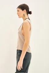 Top sin mangas de tejido de punto compacto con escote en U pronunciado. Presenta una textura sedosa y brillante, con un diseño ajustado al cuerpo.