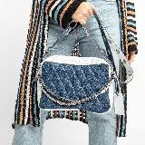 Bolso bandolera de cuero vacuno azul y blanco con diseño acolchado. Tiene correa larga ajustable y correa corta de cadena y cuero. El interior está forrado y cuenta con un bolsillo con cierre y otro para el móvil.