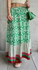 Falda larga estampada con motivos geométricos en verde, blanco y rojo.