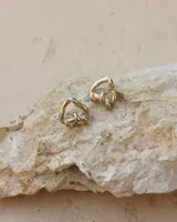 Aros de diseño minimalista en forma de corazón irregular, con acabado metálico pulido y cierre de perno con mariposa.