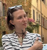 Collar con dije grande de bronce con forma orgánica y textura rugosa, suspendido de un cordón negro. Incluye cordones intercambiables.