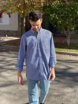 Camisa de hombre de algodón con estampado a cuadros en tonos rosado y celeste, corte clásico, manga larga, bolsillo en el pecho y botón en el cuello.