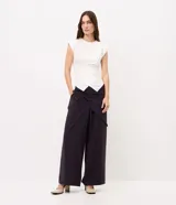 Pantalón wide leg negro de viscosa, con piernas amplias, caída fluida y detalle de pañuelo cruzado con atadura lateral en la cintura.