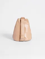 Riñonera color beige de cuero sintético, con cierre vertical y correa regulable para usar cruzada.