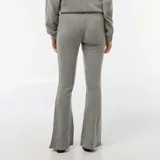 Pantalón de corte flare confeccionado en tejido de punto suave color gris, con cintura elástica y ajuste entallado en la parte superior que se ensancha hacia el ruedo.