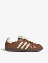 Championes Adidas Samba LT color marrón, con diseño inspirado en el fútbol, exterior de cuero, tres bandas laterales en color crema y lengüeta larga de material texturizado.