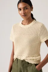 Sweater de punto color crudo, con tejido calado, manga corta y cuello redondo acanalado.