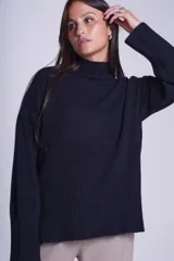 Sweater color crema de media polera, corte holgado y mangas largas. Tejido de punto con detalles acanalados en cuello, puños y ruedo.