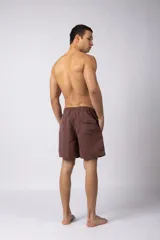 Short de baño color marrón claro con efecto acid wash, cintura elastizada con cordón ajustable y bolsillos laterales. Presenta un pequeño parche con logo en la parte inferior delantera.