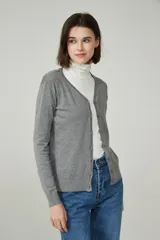 Cárdigan color beige con escote en V y cierre frontal con botones.