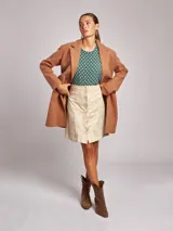 Falda mini color verde esmeralda, de corte recto con cierre frontal de botones.