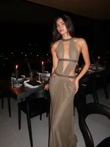 Vestido largo verde militar con escote halter profundo, recortes laterales y detalles brillantes en el cuello y la cintura.