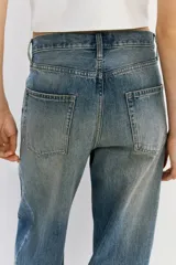 Jean de corte recto y tiro regular, confeccionado en denim de algodón en tono azul medio con efecto desteñido y diseño de cinco bolsillos.
