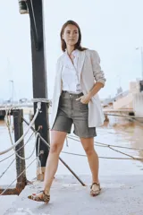 Blazer de lino blanco con solapas y detalles de volados en los puños, de corte recto y clásico.