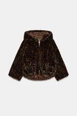 Cazadora de pelo sintético con estampado animal print, diseño con capucha, cierre frontal de cremallera metálica y bajo asimétrico.