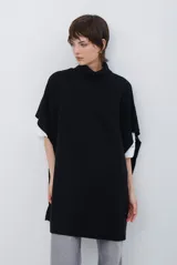 Poncho de tejido de punto en color negro, con cuello alto y diseño holgado sin mangas.