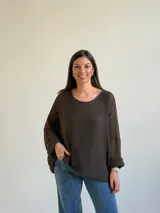 Sweater de punto abierto color marrón oscuro, de corte holgado, mangas largas y escote redondo.