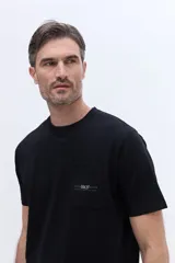 Remera de algodón color negro, con cuello redondo, mangas cortas y bolsillo frontal con logo estampado.