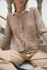 Cárdigan color beige con terminaciones en crochet y botones dorados.