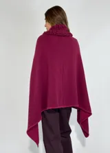 Ruana de lambswool color gris oscuro, con cuello alto y detalles bordados a mano en relieve en el cuello y a lo largo de la abertura frontal.