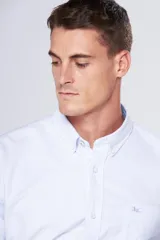 Camisa blanca de tela oxford con manga larga y logo bordado en el bolsillo. Cuello con botones y tablón central en la espalda.