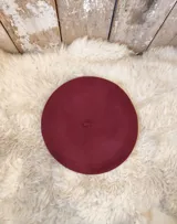 Boina de paño de lana merino afieltrada, color bordó, con diseño clásico y elegante.