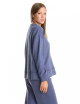 Buzo deportivo de cuello redondo, con hombros caídos y mangas largas con puños. Presenta costuras decorativas tipo pespunte en la parte frontal y en las mangas, con un diseño de ruedo recto y tajos laterales.