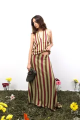 Falda larga de gasa con estampado tipográfico en color bordó sobre fondo beige. Presenta una silueta fluida y cierre lateral oculto.