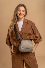 Bandolera pequeña de diseño moderno, confeccionada en tafeta liviana y resistente. Cuenta con cierre superior, correa ancha ajustable y logo frontal de la marca.