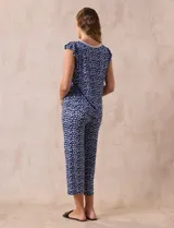 Conjunto de pijama marca René Rofé, compuesto por remera de mangas cortas con escote en V abotonado y pantalón capri con cintura elastizada. Diseño estampado con flores azules sobre fondo blanco.