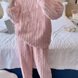 Conjunto de pijama de dos piezas confeccionado en plush suave con textura de ochos. Incluye una remera de manga larga con cuello redondo y un pantalón de corte recto con cintura elástica.