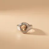 Anillo tipo sello de plata 925 con aplique central de oro 9k en forma de gorro de chef, rodeado por un detalle texturizado.