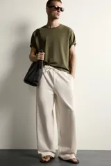 Pantalón de corte wide fit confeccionado en algodón con interior de rizo. Presenta cintura elástica con cordón ajustable y bolsillos laterales.