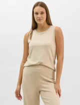 Musculosa de tejido fino en color beige, con cuello redondo y diseño básico sin mangas.