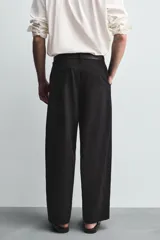 Pantalón de corte balloon fit confeccionado en una mezcla de lyocell y algodón. Presenta cierre frontal con cremallera y botón, bolsillos laterales y bolsillos traseros de vivo.