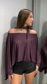 Top de corte capa con escote hombros descubiertos y detalle de cuello tipo choker integrado con tira larga. Confeccionado en tejido con acabado brillante y textura sutil.