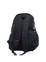 Mochila negra con bolsillo frontal que presenta un estampado abstracto en tonos rojos y negros, con el logo Umbro en blanco superpuesto. Incluye logo Umbro bordado en rojo en la parte superior y un bolsillo lateral de malla para botella.