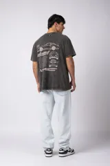 Remera negra con efecto acid wash, corte holgado y estampa frontal con logos y diseño de automovilismo.