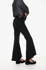 Jean elastizado azul oscuro con diseño de volados en la parte baja de la pierna, ruedo descosido con juego de largos (más largo atrás que adelante).