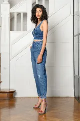 Pantalón de jean celeste con roturas, tiro alto, corte holgado y tobillos ajustados.