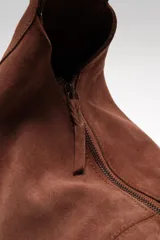 Bolso tote de ante suave, de cuerpo blando estilo hobo, con asa larga para el hombro y cierre superior con cremallera.